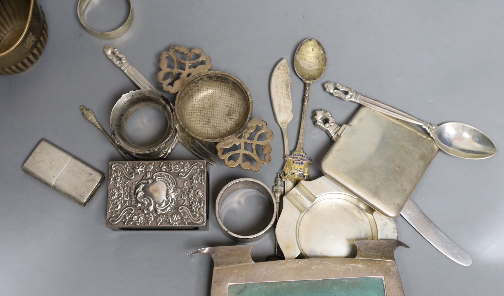 Assorted silver including a Victorian bullet shaped teapot, Arthur Sibley, London, 1878, height 12.1cm, sauceboat, cream jug, sugar bowl, cup, tea strainer, watch holder, match sleeve, pair of ashtrays, lighter, three na